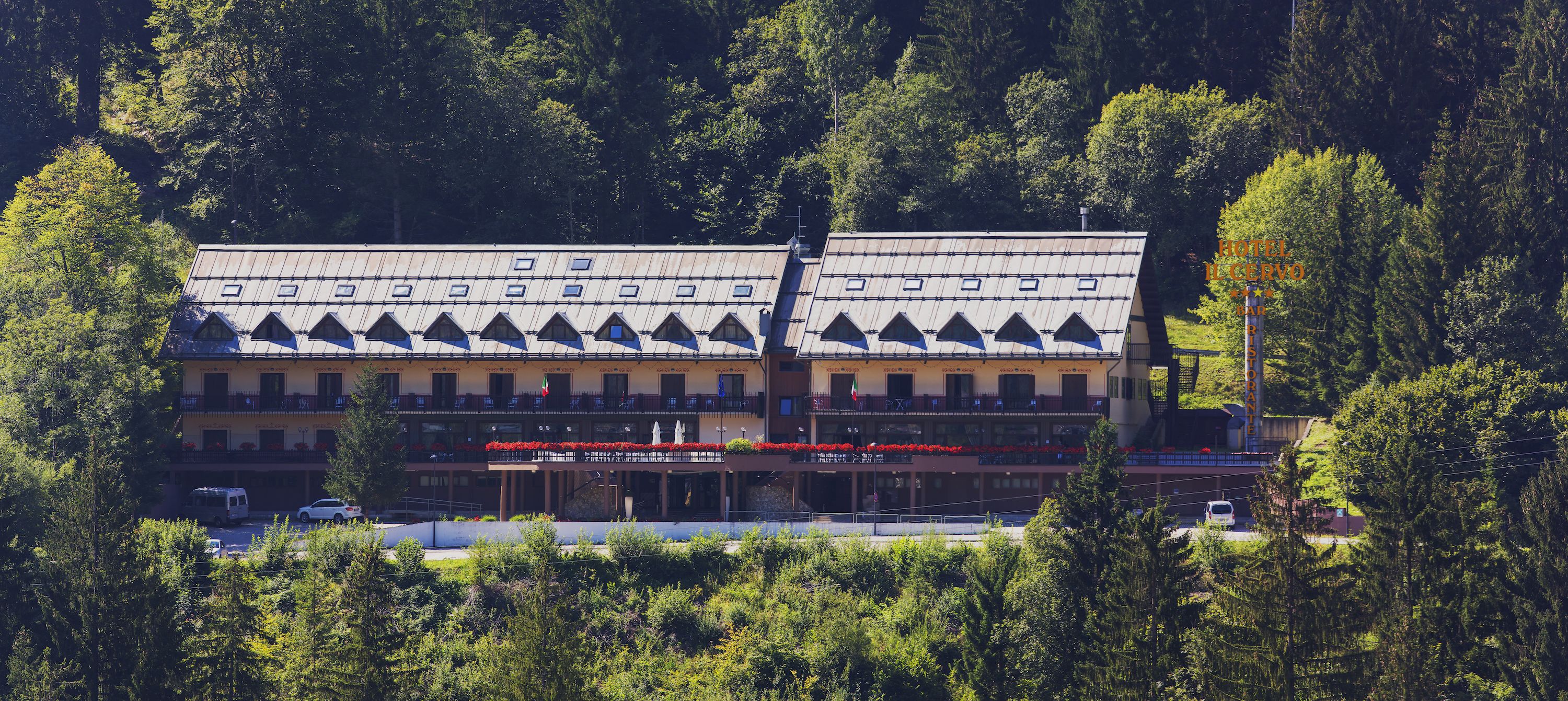 Un hotel con facciata simmetrica, numerosi balconi e un ingresso centrale.