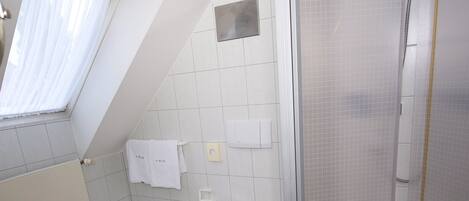 Ein modernes Badezimmer mit Dusche, Toilette und Badewanne.