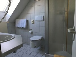 Un baño moderno con inodoro, lavabo y ducha.