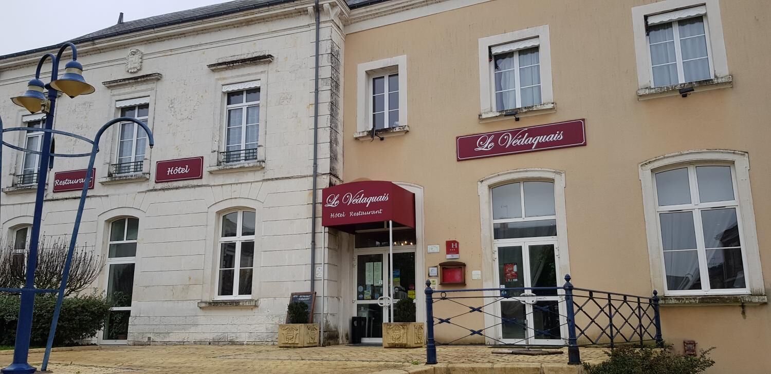 A building with signs for 'Hôtel' and 'Le Védaguais Hotel Restaurant'.