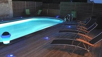 Alberca al aire libre y camastros