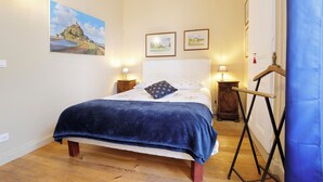 A bedroom with a bed, two bedside tables, a dresser, and a painting on the wall. - Relais Saint Louis (Belleme)