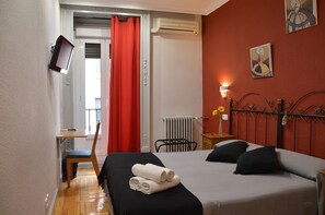 Enjoy a restful stay in this simply designed room featuring a comfortable bed, bedside table, and wall-mounted TV.