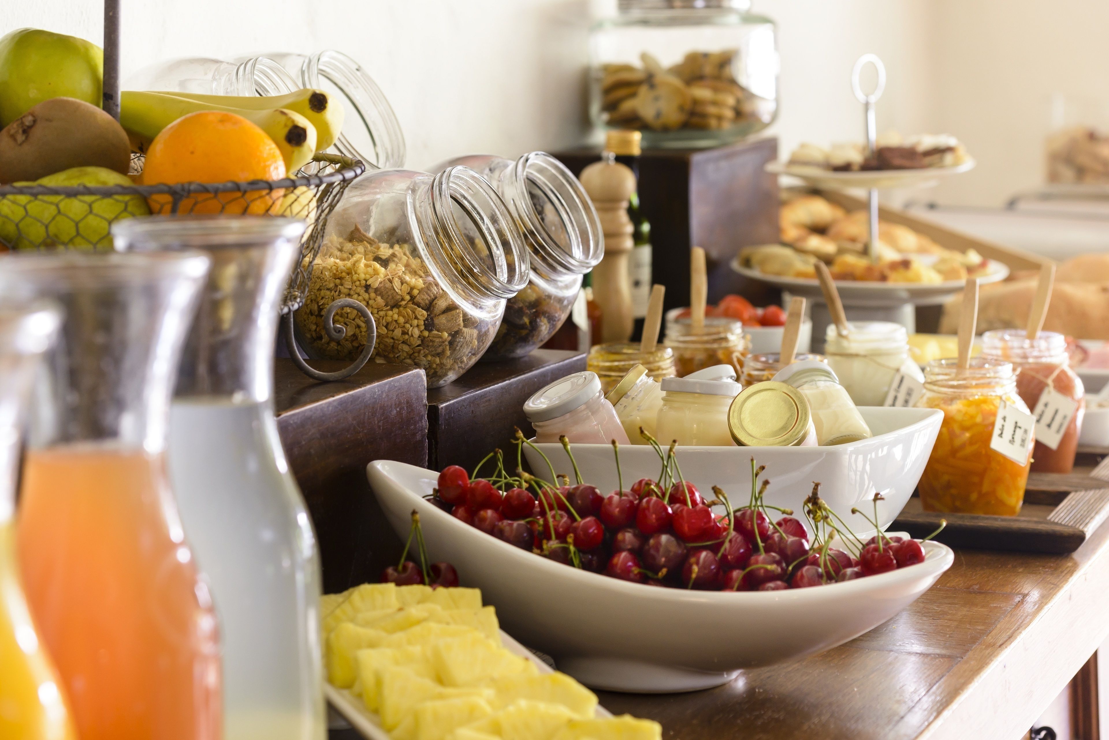 A buffet with various food items including fruits, cheeses, and spreads.
