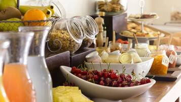 A buffet with various food items including fruits, cheeses, and spreads.