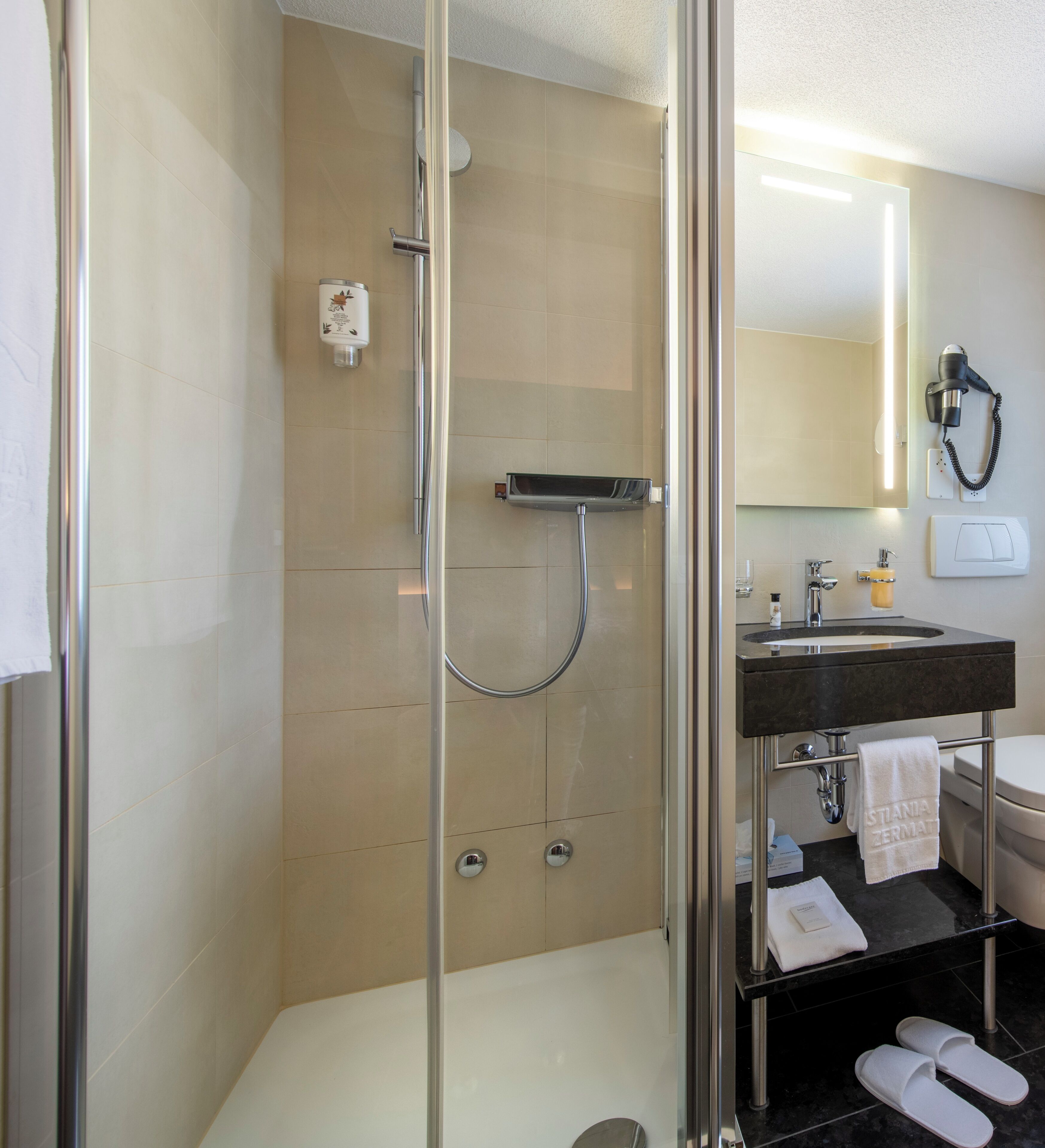 Une salle de bain moderne avec une douche à parois de verre, un lavabo avec un miroir et un porte-serviettes.