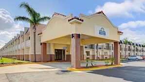 Un bâtiment de la chaîne Days Inn & Suites, avec une façade beige, de nombreux balcons et un parking.