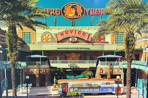 Ein Theater mit einer Litfaßsäule, auf der 'Muvico 10' und 'TropiYBOP' stehen.