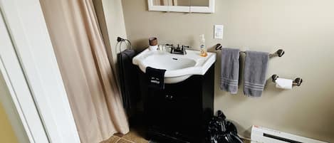 Un baño con lavabo, espejo, toallero, inodoro y calefacción.