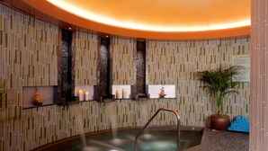 A spa area with a hot tub, tiled walls, and a potted plant. - Northern Quest Resort And Casino (Airway Heights)