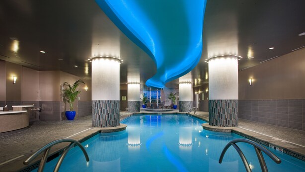 A modern indoor swimming pool with clear water, surrounded by a tiled floor and walls, and illuminated by overhead lighting. - Northern Quest Resort And Casino (Airway Heights)