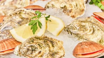 A platter of oysters on ice with lemon wedges and parsley garnish.