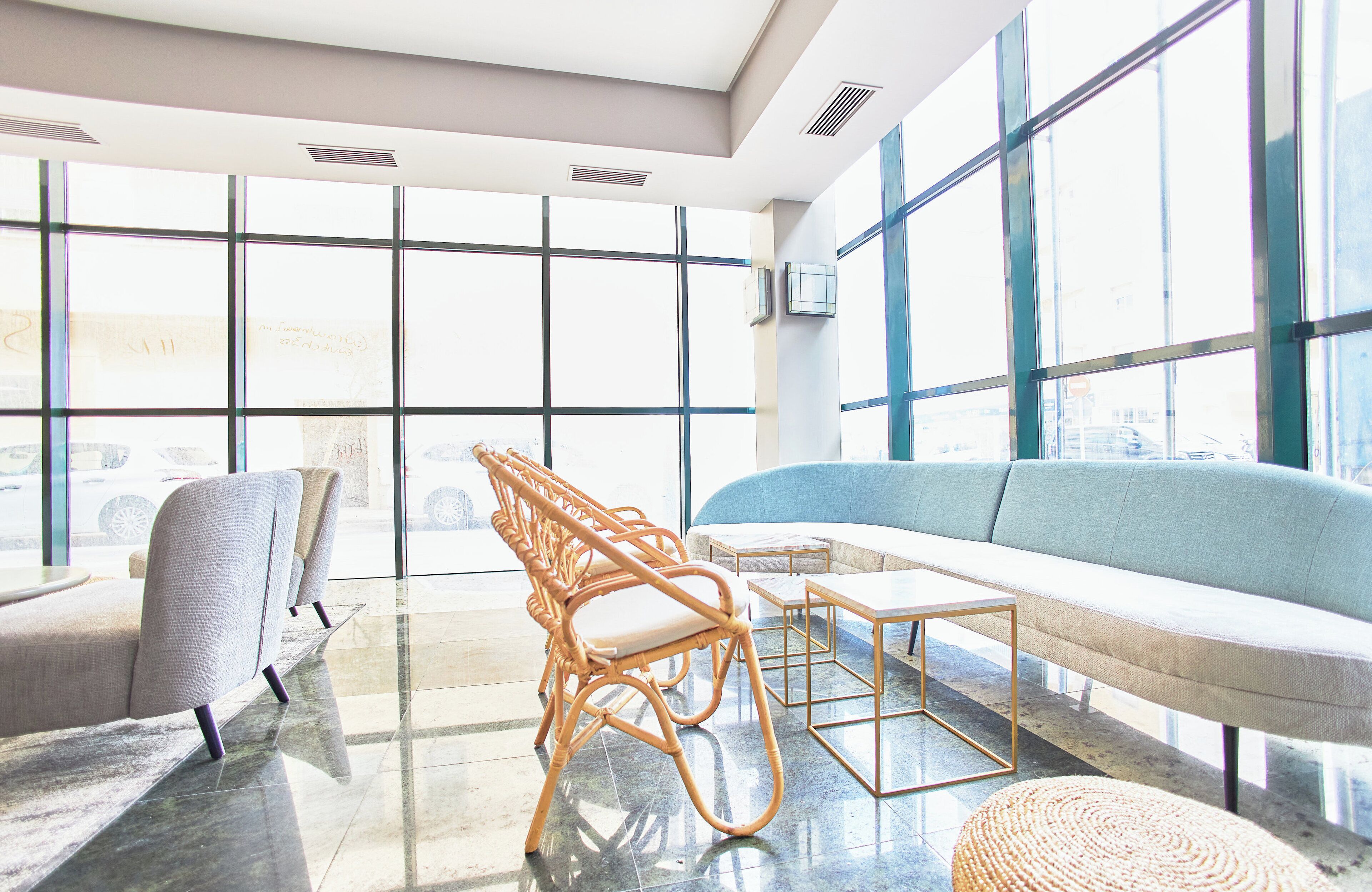 Un salón moderno con sofá, sillones y una mesa de centro.