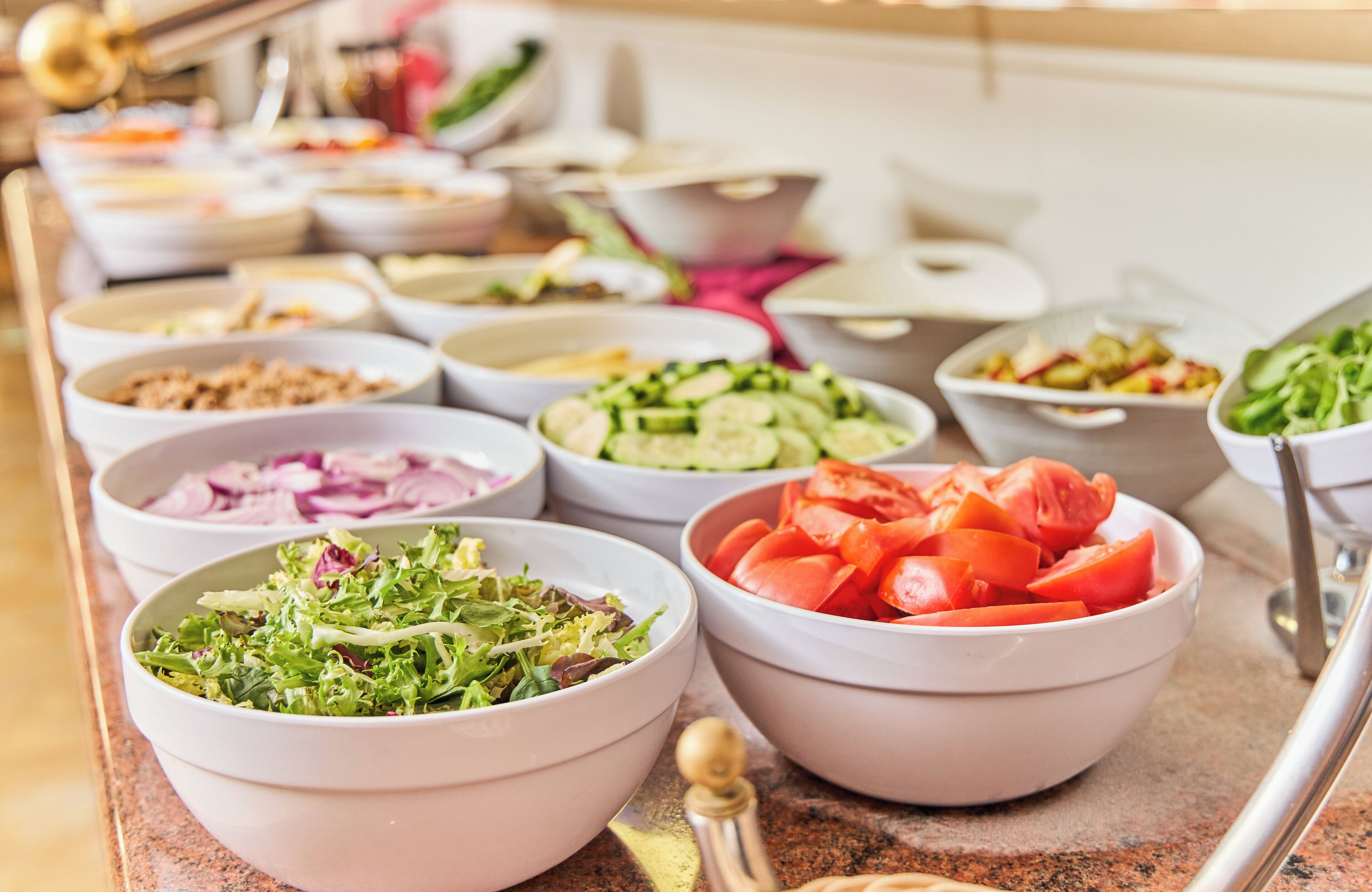 A buffet with various dishes including salads, vegetables, and meats.