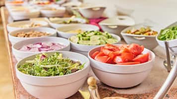 A buffet with various dishes including salads, vegetables, and meats.