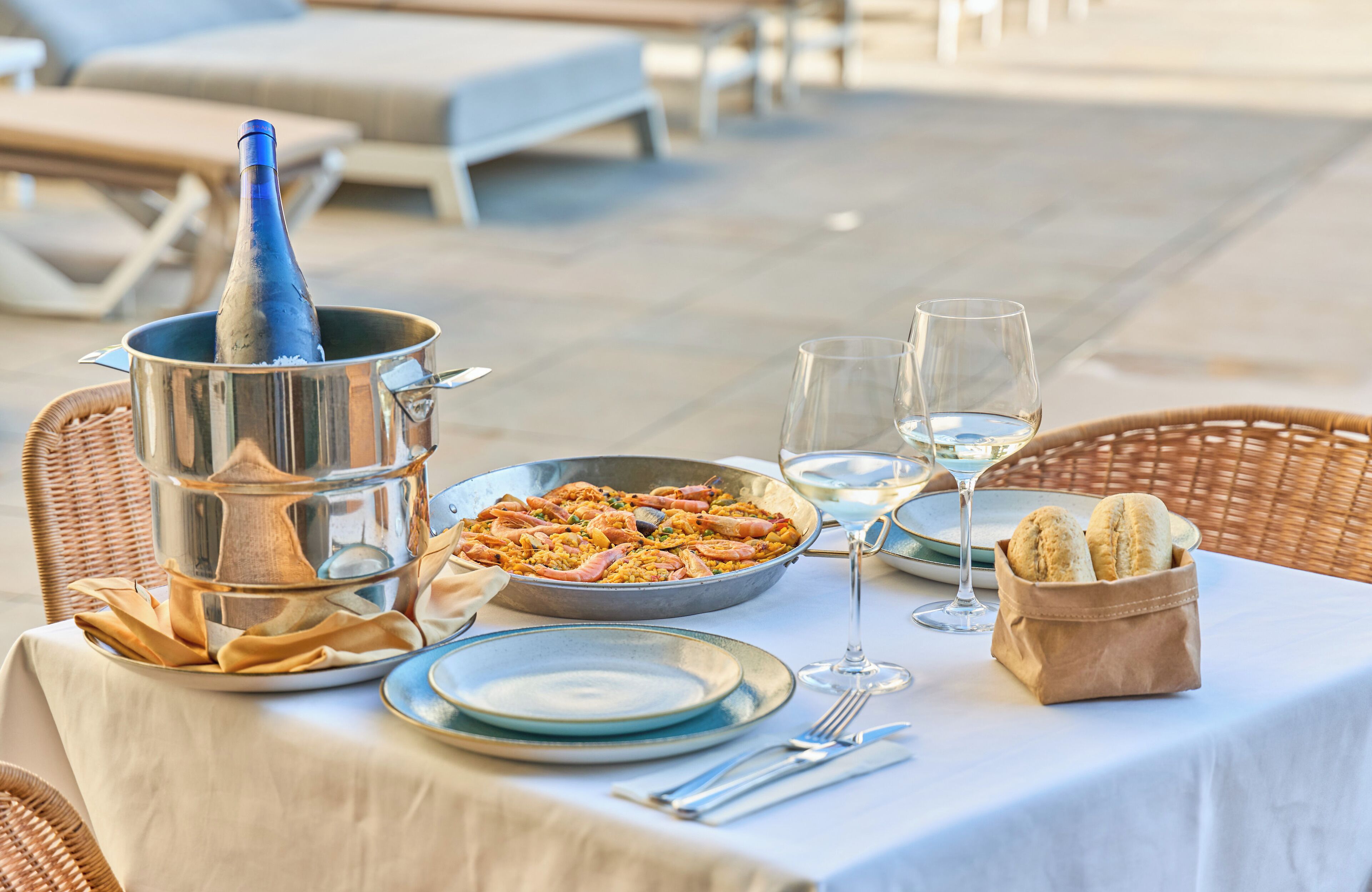 A table set for a meal with seafood, wine glasses, and bread.