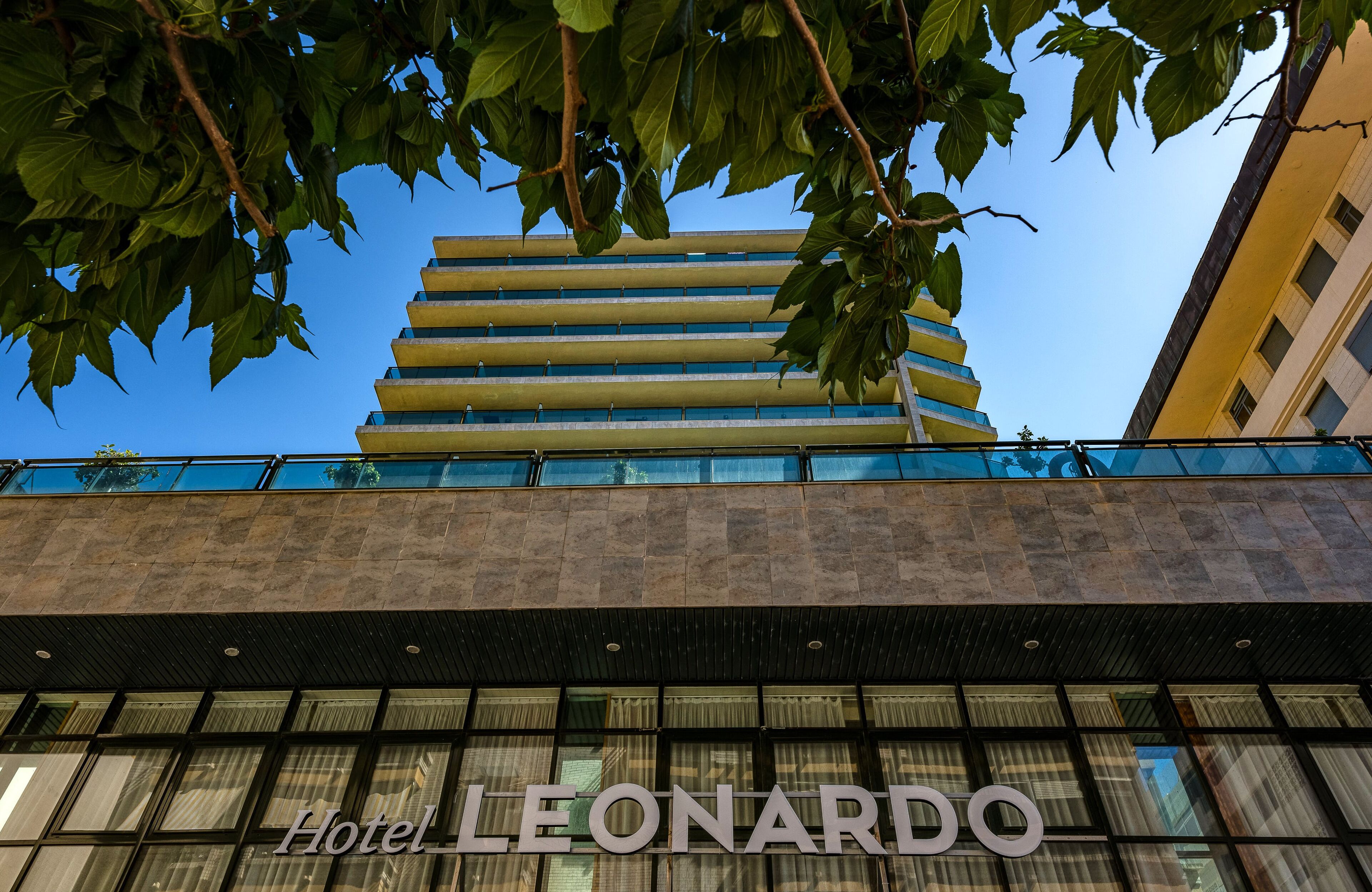 Hotel Leonardo with a modern facade, large windows, and a prominent name sign.