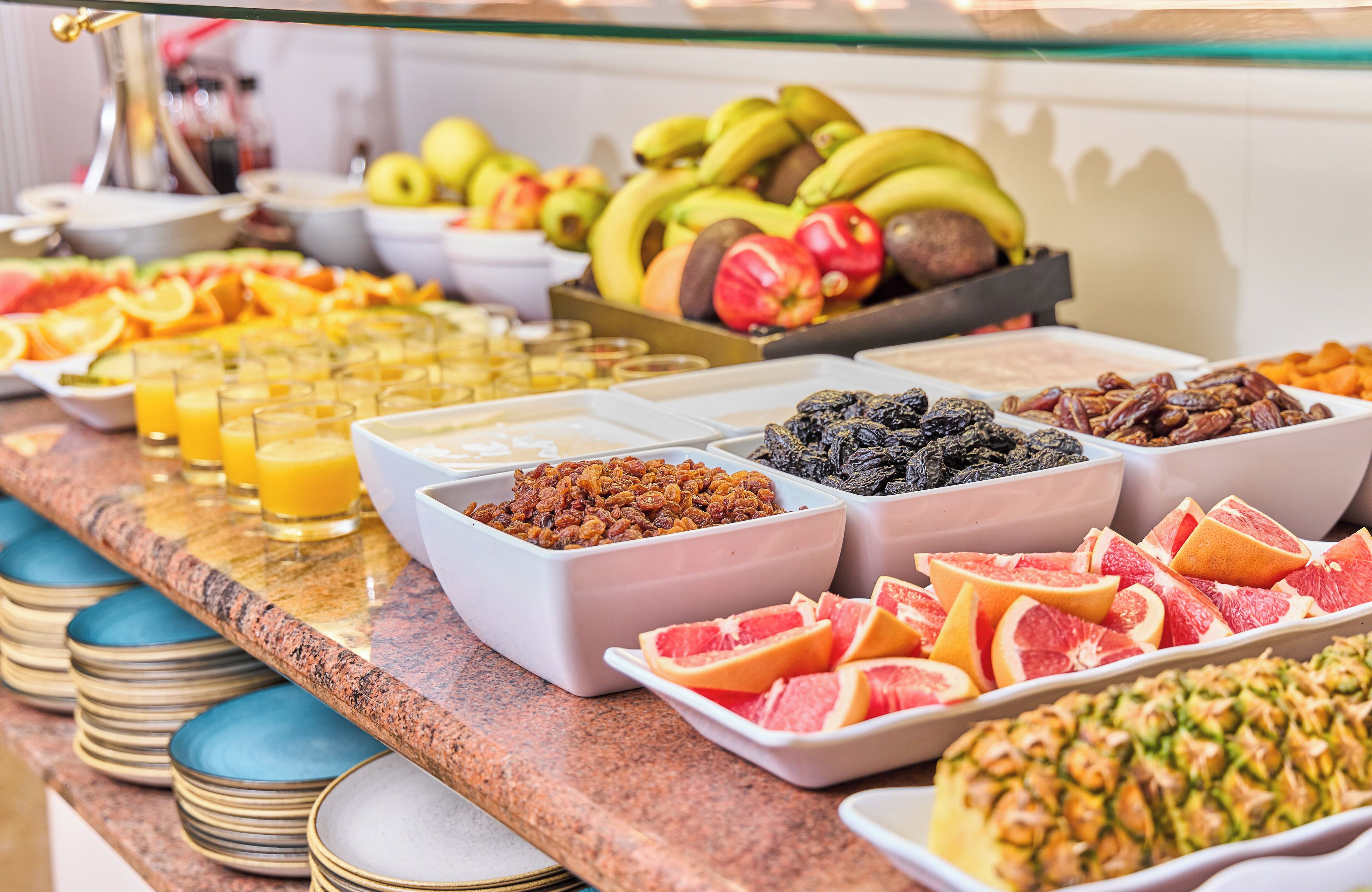 A buffet with various fruits, nuts, and juices.