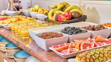 A buffet with various fruits, nuts, and juices.