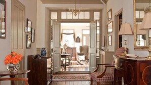 A room with a wooden floor, a dining table with chairs, a sideboard, and a mirror. - The Wayside Inn Bed & Breakfast (Ellicott City)