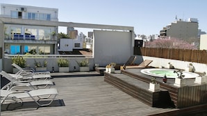 A rooftop terrace with lounge chairs, a hot tub, and potted plants. - Didi Rooms (Buenos Aires)