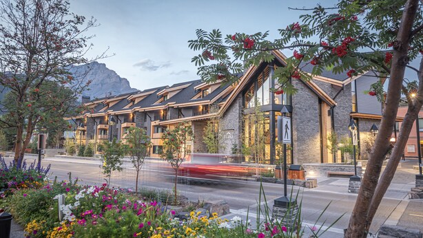 A modern hotel with a stone facade, large windows, and a rooftop terrace. - Peaks Hotel & Suites (Banff)