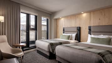Une chambre d’hôtel avec deux lits, une chaise, une petite table et une vue sur l’extérieur.