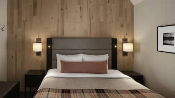 A hotel room with a wooden panel wall, a bed with white bedding and a brown pillow, two bedside lamps, and a framed picture on the wall.