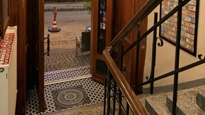 A staircase with a wooden railing and a patterned floor leading to a door with a glass panel. - Antique Hostel & Guesthouse (Istanbul)