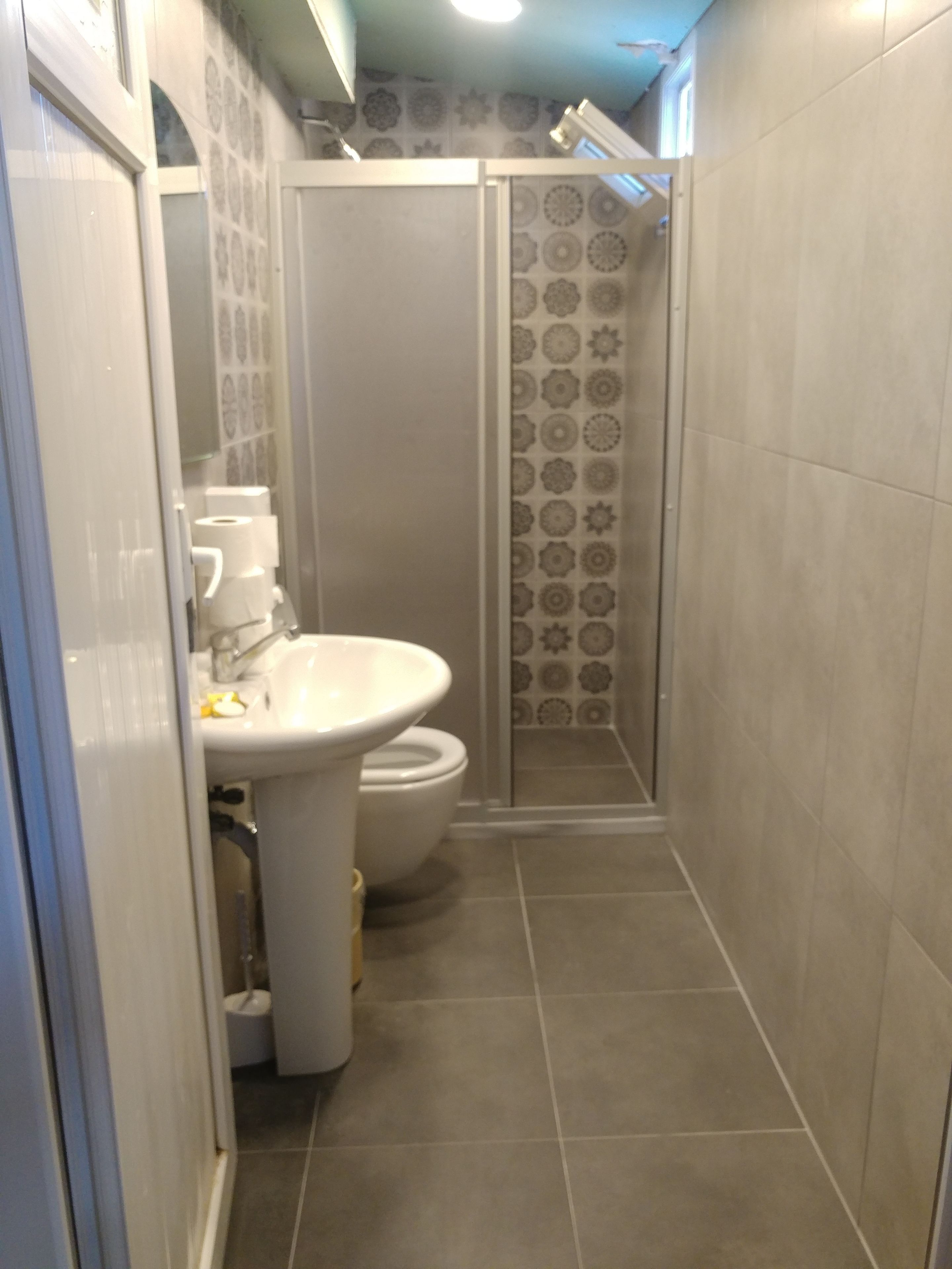 Une salle de bain comprenant des toilettes, un lavabo et une douche.
