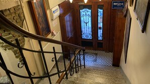 A staircase with a wrought iron railing, a wooden door with a glass panel, and a sign indicating a no smoking area. - Antique Hostel & Guesthouse (Istanbul)