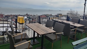 A terrace with wicker furniture and a view of the sea. - Antique Hostel & Guesthouse (Istanbul)