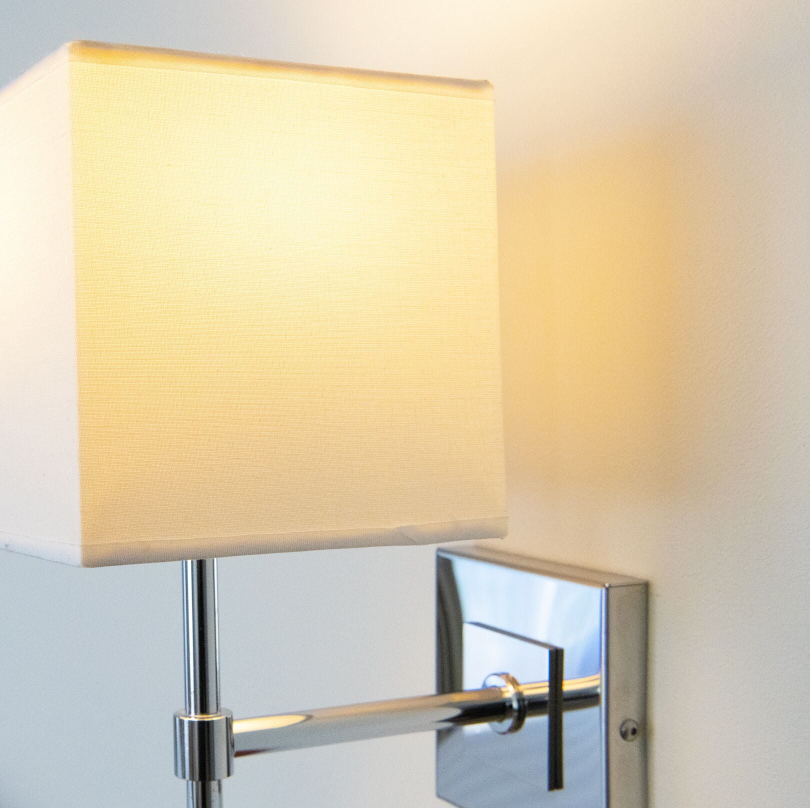 A modern lamp with a square shade mounted on a chrome stand.