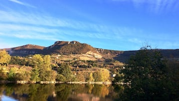 Uma paisagem tranquila com uma montanha, um lago e uma pequena aldeia.