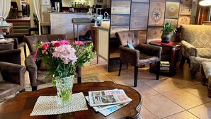 A cozy restaurant interior with a bar area, comfortable seating, and decorative wall panels.