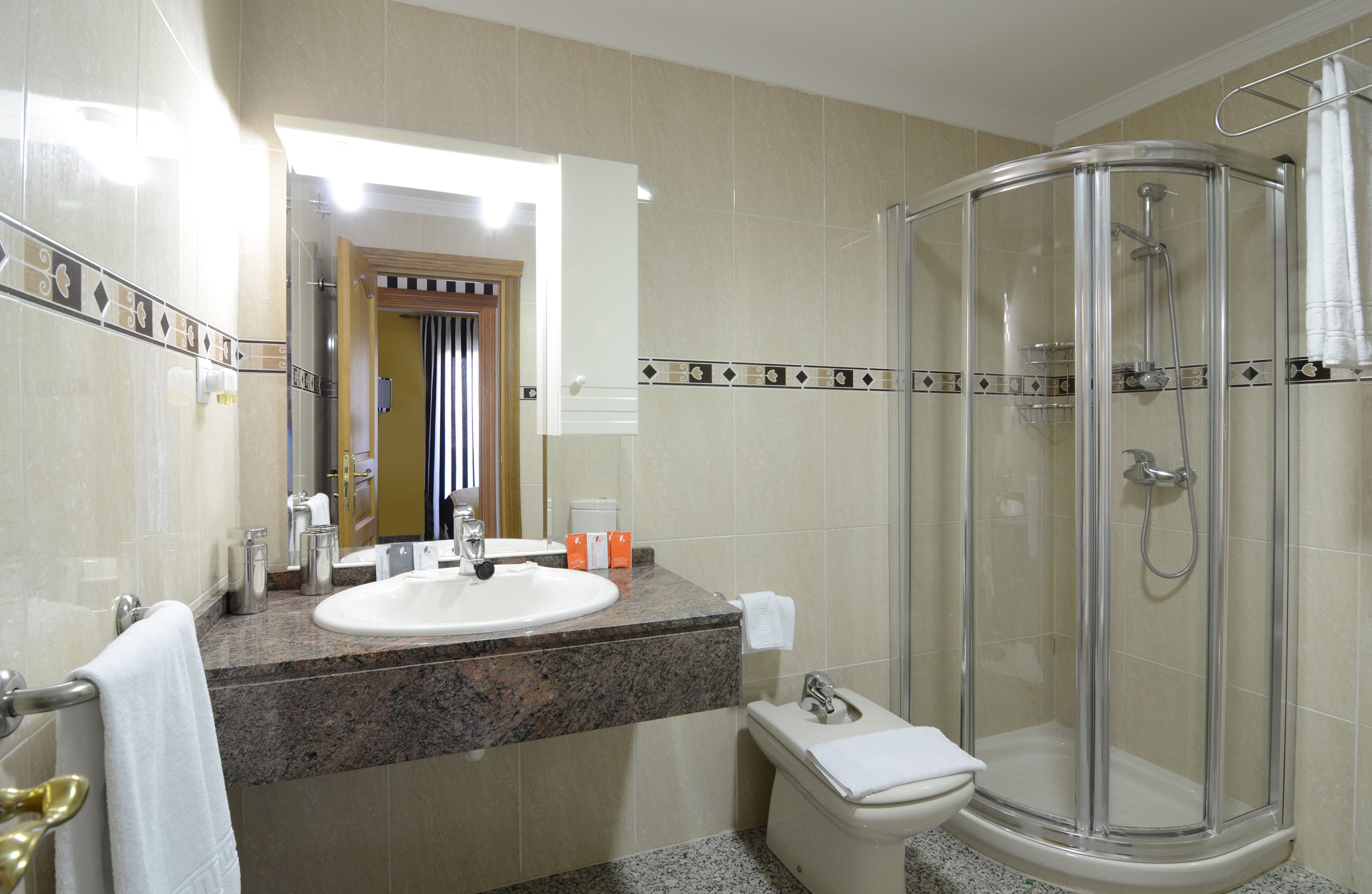 Ein Badezimmer mit Waschbecken, Toilette und einer Duschkabine.