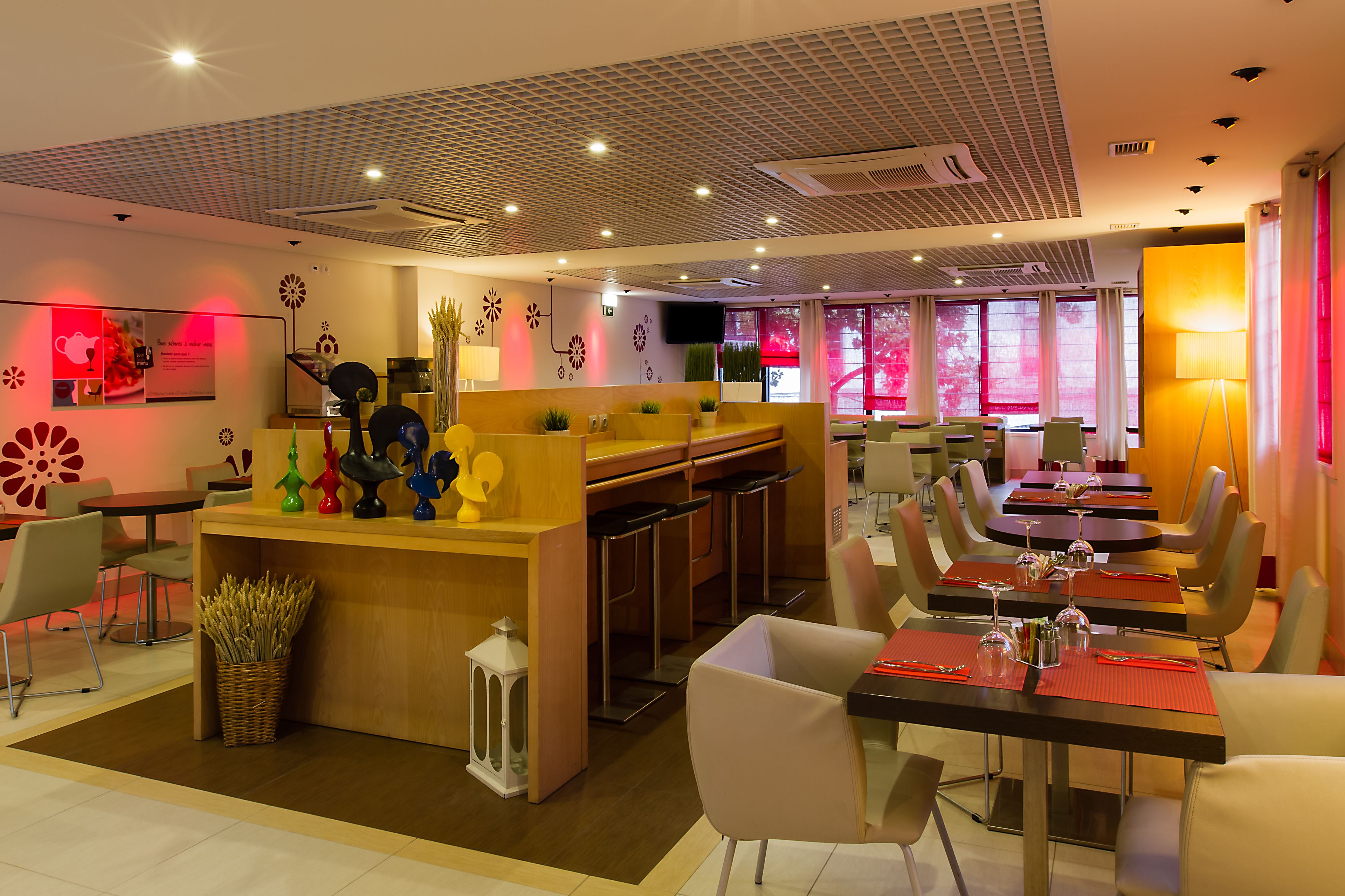 A modern restaurant with a bar area, multiple dining tables, and chairs.