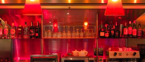A bar area with shelves of liquor bottles, a coffee machine, and a microwave.