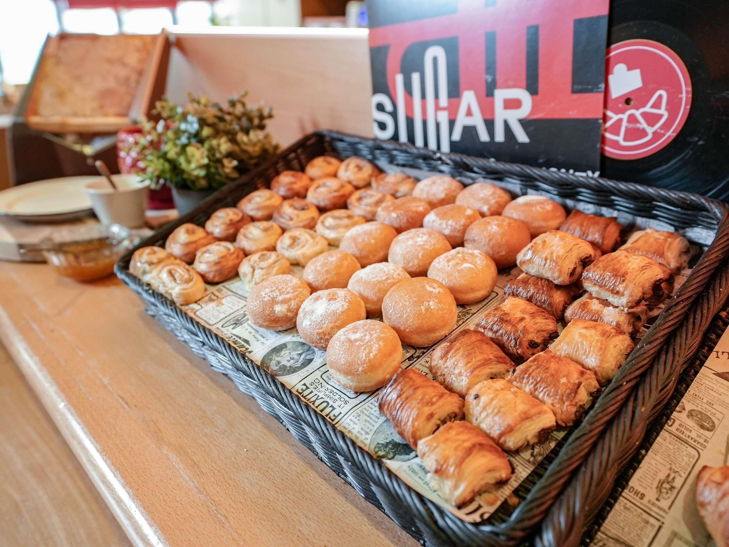 Un panier rempli de diverses pâtisseries est posé sur une table.