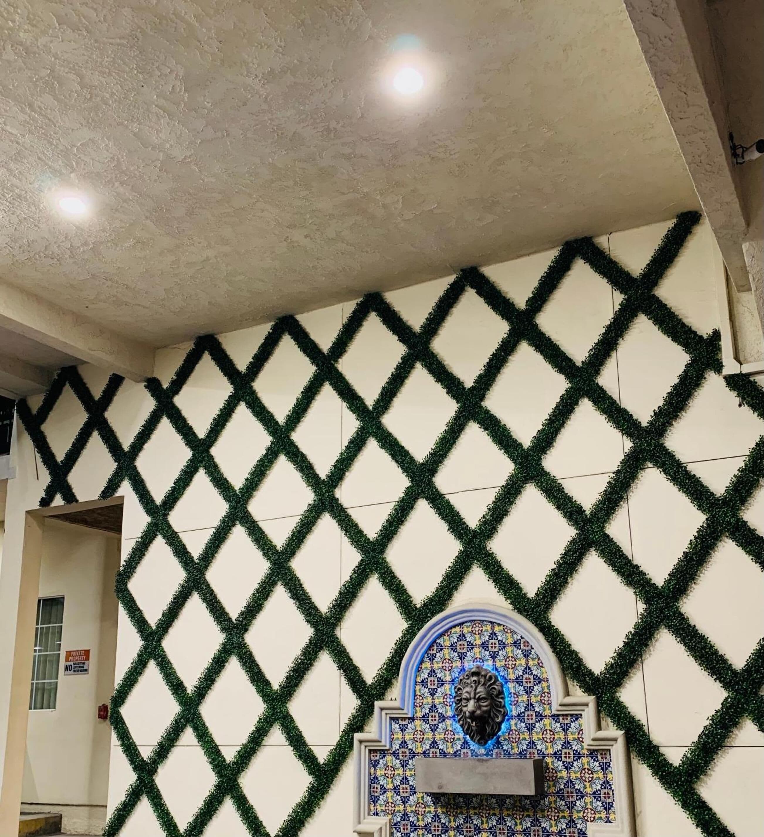 A wall with a diamond pattern and a decorative tile with a lion's face.