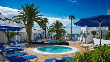 Una piscina al aire libre, sombrillas