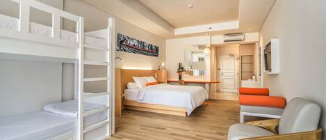 Une chambre d’hôtel moderne équipée de lits superposés, d’un bureau, d’une chaise et d’un lit avec une table de chevet.
