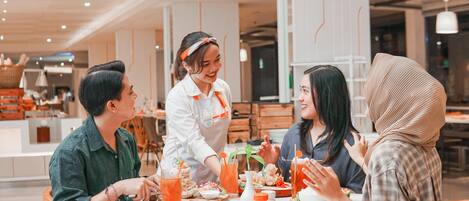 A group of people dining at a restaurant with a modern interior, white walls, and wooden furniture.