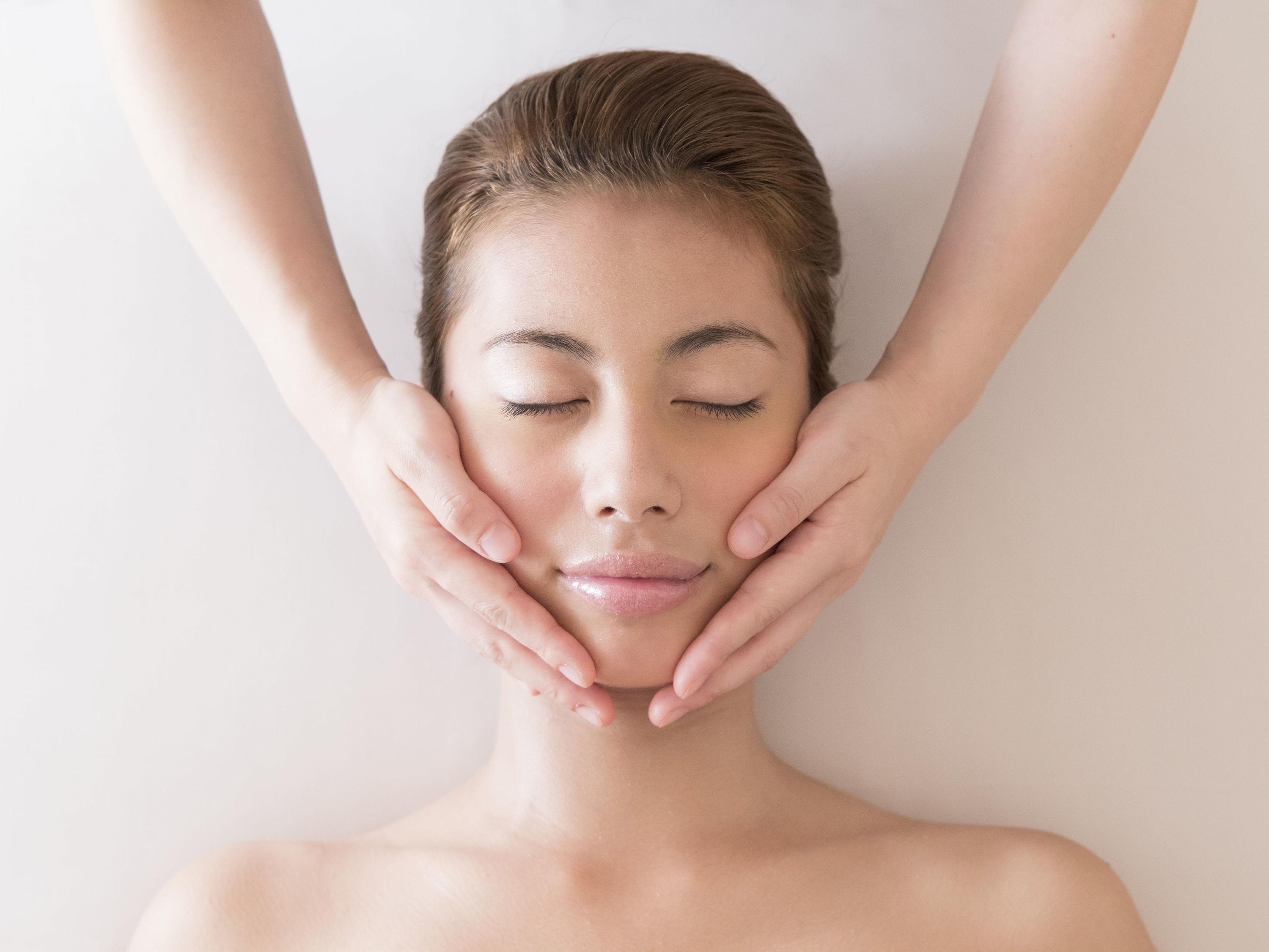 A person lying down with hands placed on their face.