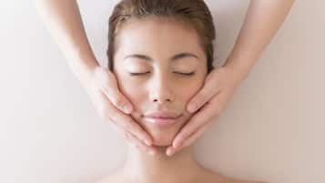 A person lying down with hands placed on their face.