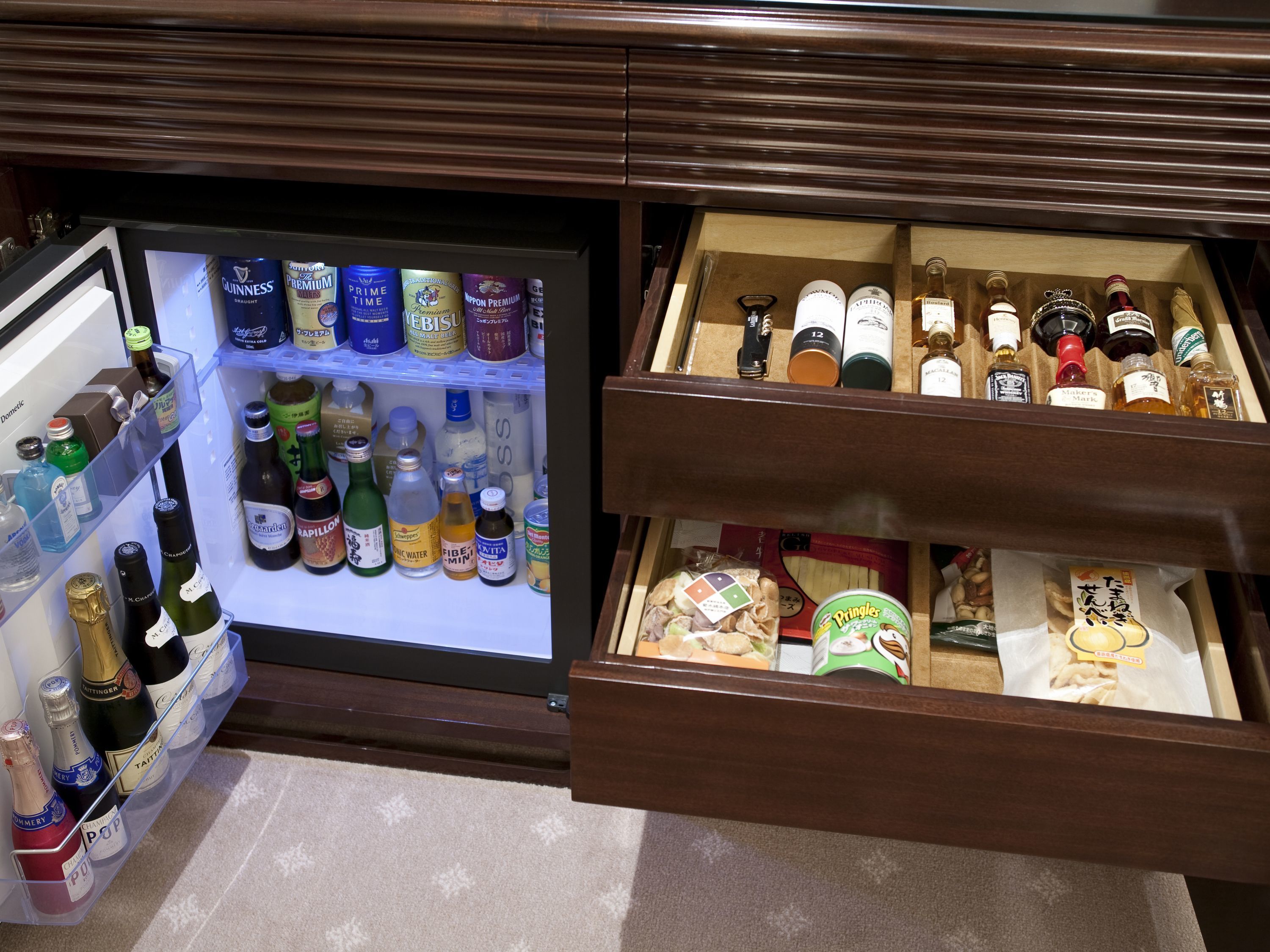 A minibar with a variety of alcoholic beverages and snacks.