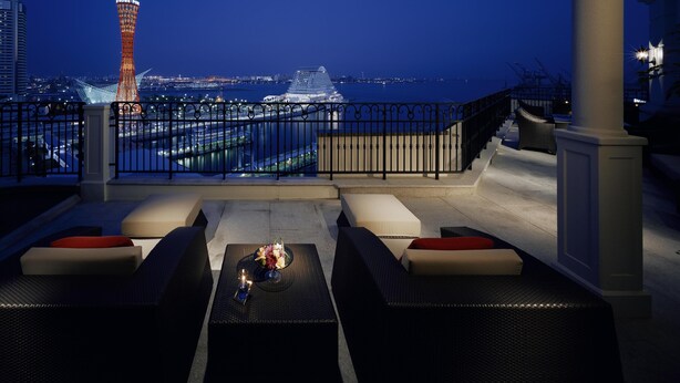 A rooftop terrace with outdoor seating, a view of a cityscape at night, and a prominent tower in the background. - Hotel La Suite Kobe Harborland (Kobe)