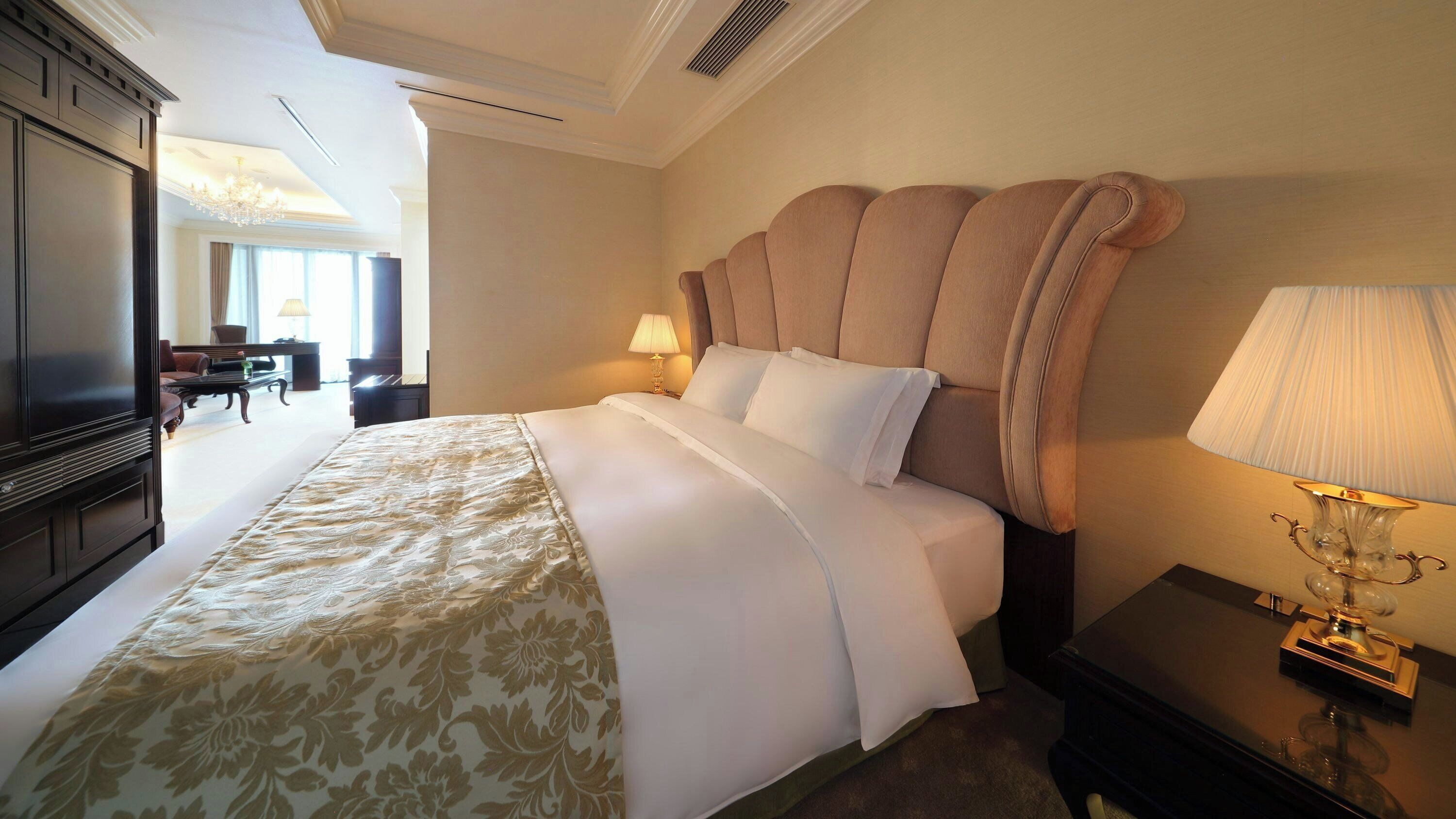 Una habitación de hotel con una cama grande, televisor, escritorio y lámpara.