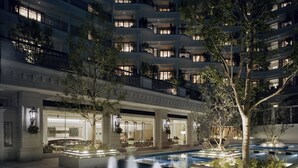 A hotel courtyard with a fountain, outdoor seating, and a building with multiple balconies. - Hotel La Suite Kobe Harborland (Kobe)