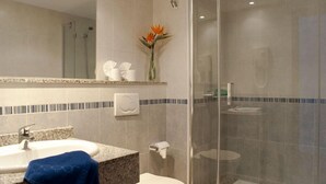 A bathroom with a sink, toilet, and shower area. - Apartamentos Flamingo (Tías)